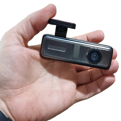 Dash camera held in a hand for size comparison